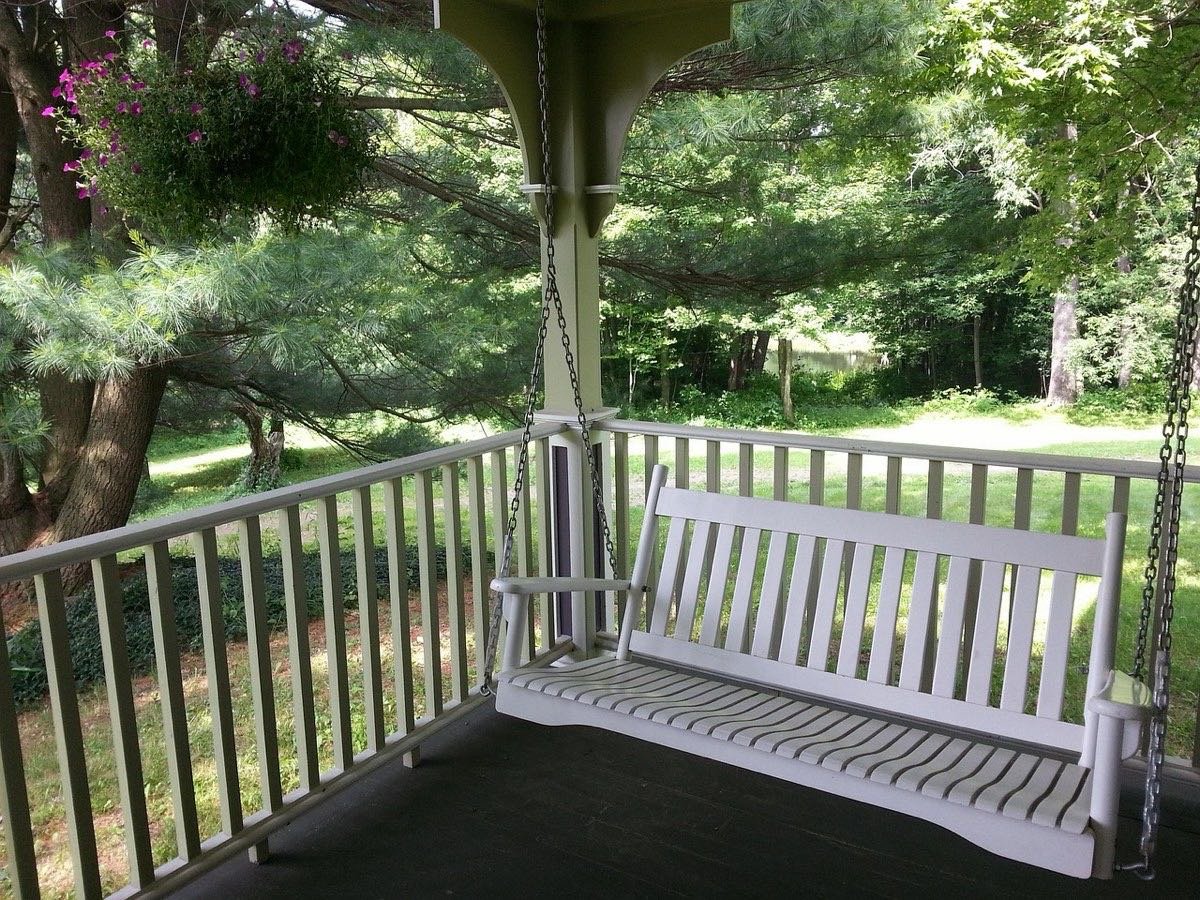 Quiet porch with a swing overlooking a green garden